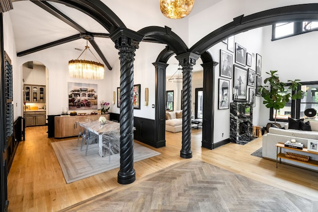 2621 Exposition Blvd, Austin, TX 78703 - dining area featuring arched walkways, decorative columns, healthy amount of natural light, a towering ceiling, and a chandelier