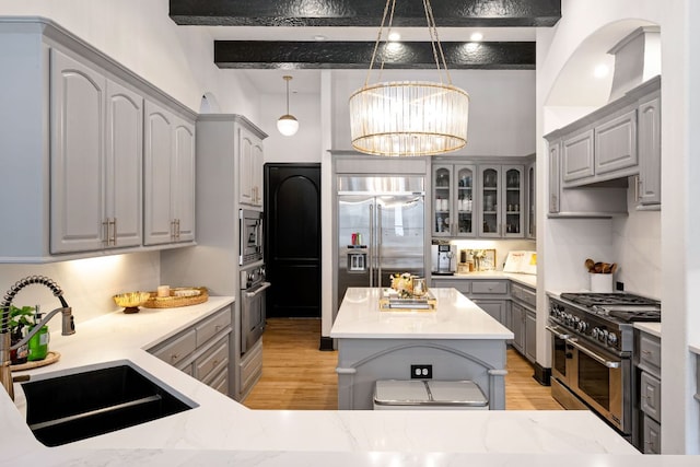 2621 Exposition Blvd, Austin, TX 78703 - kitchen featuring gray cabinets, built in appliances, a sink, light wood-type flooring, and a chandelier