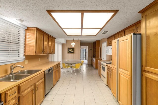 6203 Shadow Mountain Cv, Austin, TX 78731 - kitchen featuring white appliances, a sink, light countertops, light tile patterned floors, and brown cabinets