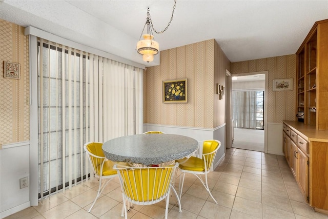 6203 Shadow Mountain Cv, Austin, TX 78731 - dining room featuring wallpapered walls, a wainscoted wall, and light tile patterned floors