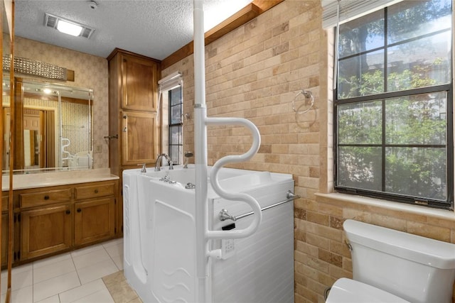 6203 Shadow Mountain Cv, Austin, TX 78731 - bathroom with a textured ceiling, vanity, tile patterned flooring, toilet, and wallpapered walls