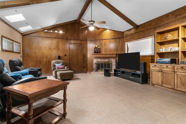 6203 Shadow Mountain Cv, Austin, TX 78731 - living room featuring wood walls, a brick fireplace, light tile patterned floors, a skylight, and a ceiling fan