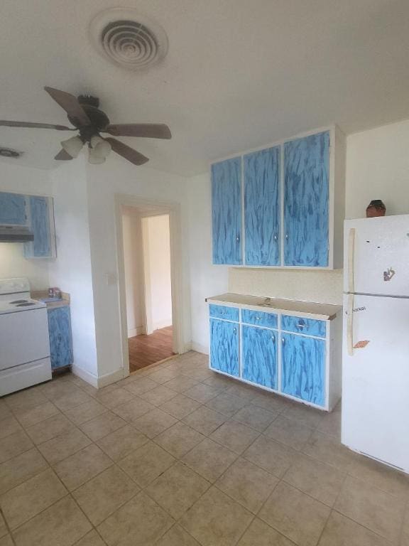 8164 Ranch Road 261, Buchanan Dam, TX 78609 - kitchen with white appliances, under cabinet range hood, ceiling fan, light countertops, and baseboards