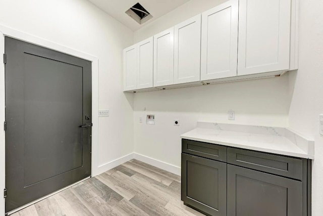 4190 W Fm 243, Bertram, TX 78605 - washroom featuring cabinet space, hookup for an electric dryer, washer hookup, light wood-style floors, and baseboards
