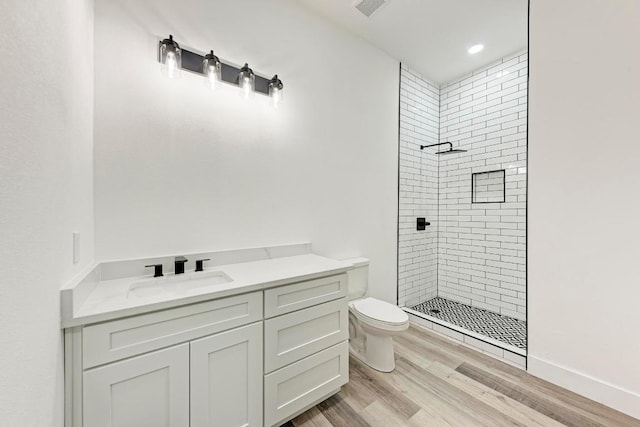 4190 W Fm 243, Bertram, TX 78605 - bathroom with toilet, a tile shower, vanity, wood finished floors, and recessed lighting