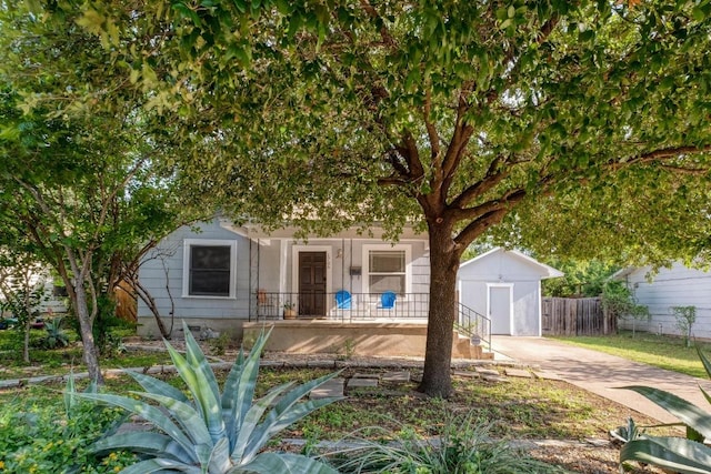 1706 Pennsylvania Ave, Austin, TX 78702 - view of property hidden behind natural elements featuring a storage unit, covered porch, and concrete driveway