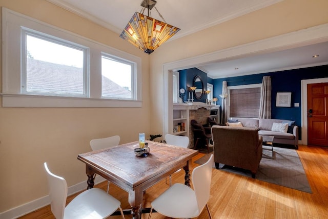 1706 Pennsylvania Ave, Austin, TX 78702 - dining area with ornamental molding, a chandelier, light wood-style flooring, and a fireplace
