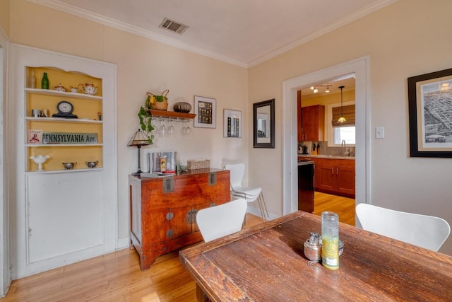 1706 Pennsylvania Ave, Austin, TX 78702 - dining space featuring light wood finished floors and crown molding