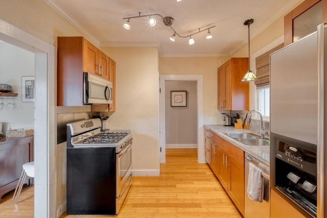 1706 Pennsylvania Ave, Austin, TX 78702 - kitchen with stainless steel appliances, light wood-style flooring, light countertops, ornamental molding, and pendant lighting