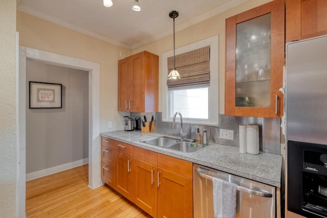 1706 Pennsylvania Ave, Austin, TX 78702 - kitchen with appliances with stainless steel finishes, light countertops, ornamental molding, light wood-type flooring, and brown cabinets