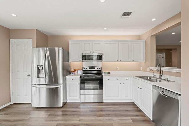 509 Big Bend Trl, Taylor, TX 76574 - kitchen featuring stainless steel appliances, a sink, light countertops, white cabinetry, and recessed lighting