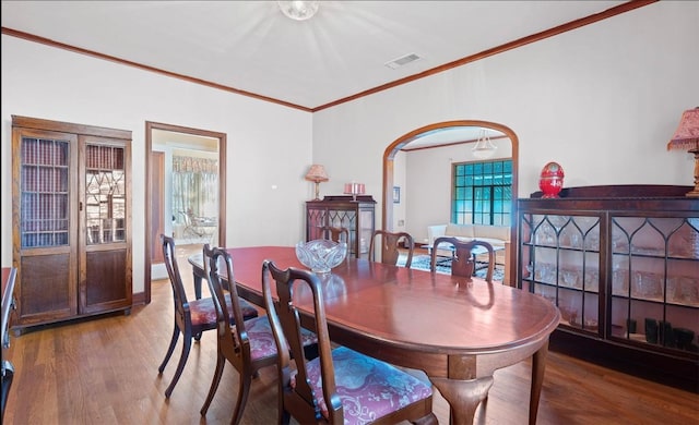 762 S Guadalupe St, Lockhart, TX 78644 - dining room featuring wood finished floors, crown molding, and arched walkways