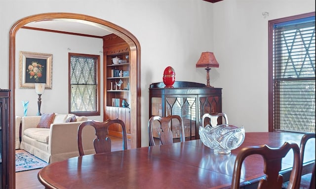 762 S Guadalupe St, Lockhart, TX 78644 - dining room with built in shelves, arched walkways, ornamental molding, and wood finished floors