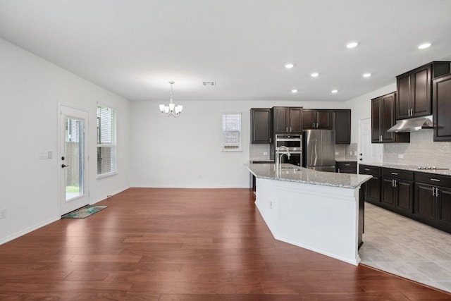 104 Kulmbacher Dr, Austin, TX 78728 - kitchen with stainless steel appliances, under cabinet range hood, a chandelier, light wood-type flooring, and recessed lighting