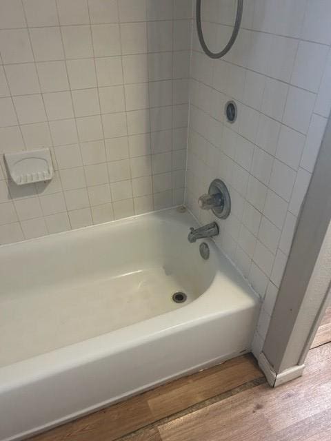 1008 Washburn St, Taylor, TX 76574 - bathroom with wood finished floors and shower / washtub combination