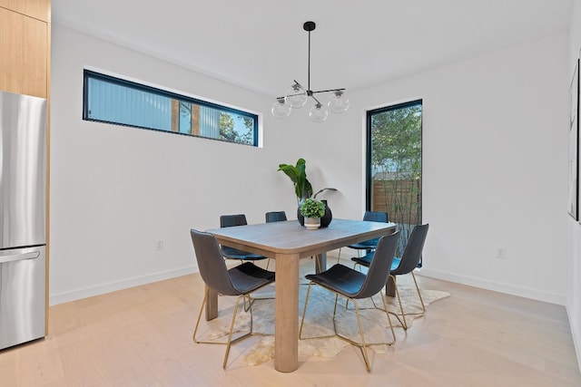 2704 Canterbury St Unit A, Austin, TX 78702 - dining area with light wood-type flooring, a chandelier, and baseboards