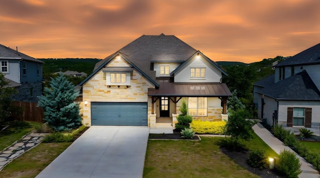 8108 Turning Leaf Cir, Lago Vista, TX 78645 - view of front of home with a standing seam roof, stone siding, an attached garage, concrete driveway, and metal roof