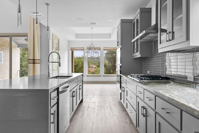 8108 Turning Leaf Cir, Lago Vista, TX 78645 - kitchen featuring a sink, a raised ceiling, stainless steel appliances, wall chimney exhaust hood, and decorative backsplash