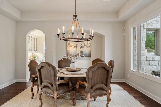 512 Newhall Cv, Austin, TX 78746 - dining area with a chandelier, arched walkways, dark wood-style flooring, and plenty of natural light