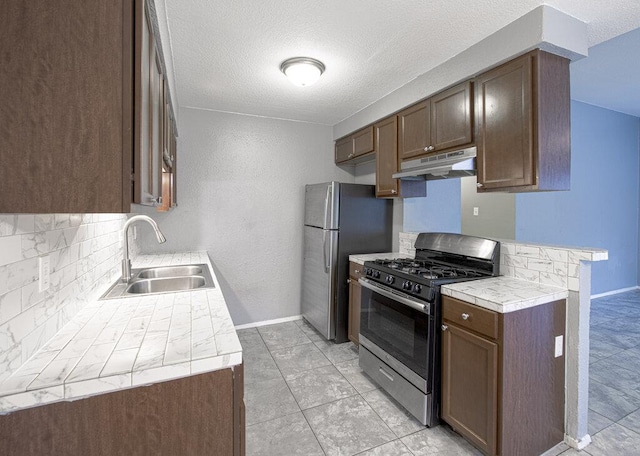 4401 Teri Rd, Austin, TX 78744 - kitchen featuring stainless steel appliances, a sink, under cabinet range hood, decorative backsplash, and tile countertops