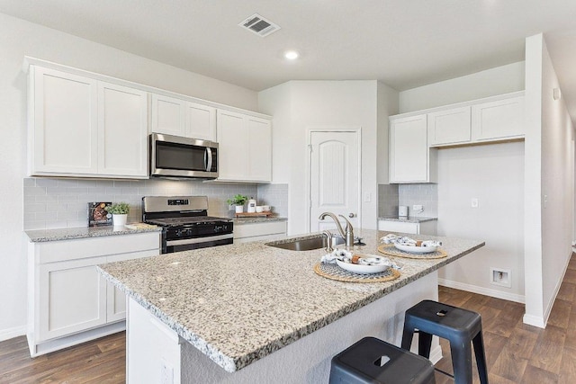 208 Charles Trl, Georgetown, TX 78626 - kitchen with stainless steel appliances, a sink, white cabinets, baseboards, and recessed lighting