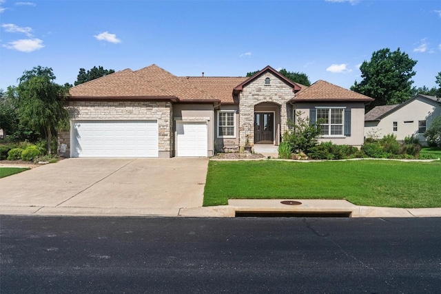 282 Trail Of The Flowers, Georgetown, TX 78633 - view of front of house with stone siding, a front yard, an attached garage, concrete driveway, and stucco siding