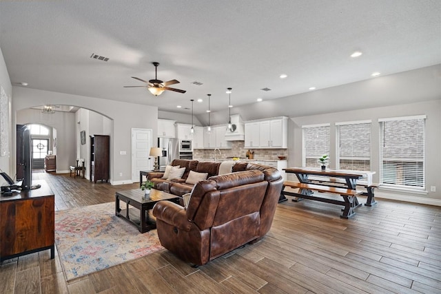 100 Indian Paintbrush Trl, Georgetown, TX 78628 - living room with dark wood-type flooring, arched walkways, ceiling fan, baseboards, and recessed lighting