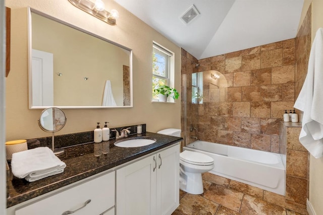 111 Adam L Chapa Sr St, Austin, TX 78702 - bathroom featuring stone tile floors, vanity, toilet, shower / washtub combination, and lofted ceiling