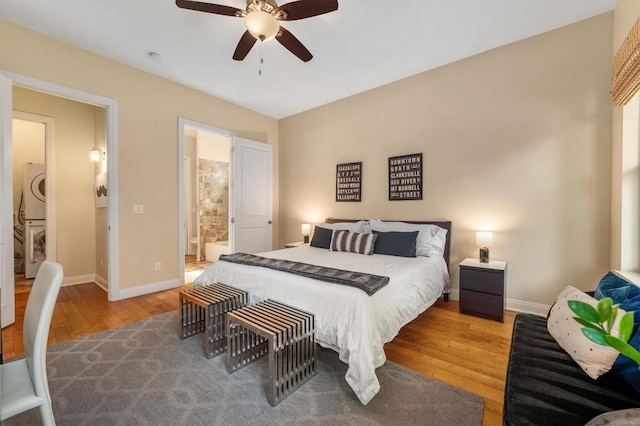 111 Adam L Chapa Sr St, Austin, TX 78702 - bedroom featuring stacked washer / dryer, wood finished floors, baseboards, connected bathroom, and ceiling fan