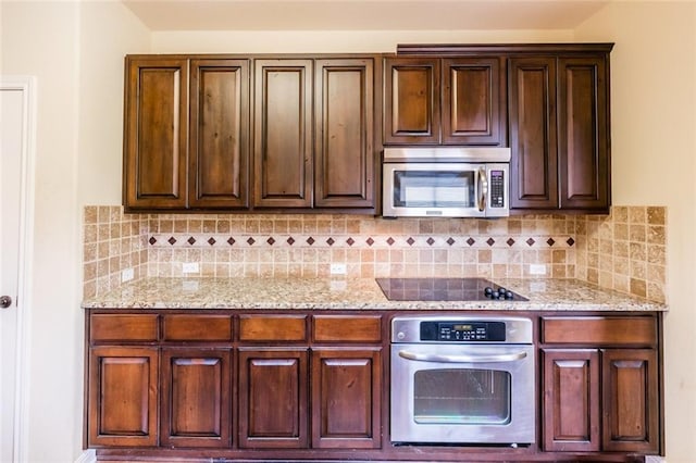 159 Catfish Cv, Dripping Springs, TX 78620 - kitchen featuring stainless steel appliances, backsplash, light stone counters, and dark brown cabinetry