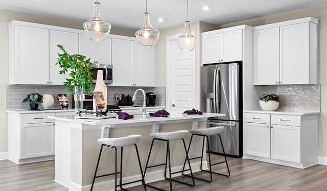 116 Alistair Dr, Georgetown, TX 78633 - kitchen with stainless steel appliances, decorative backsplash, a kitchen breakfast bar, a kitchen island with sink, and recessed lighting