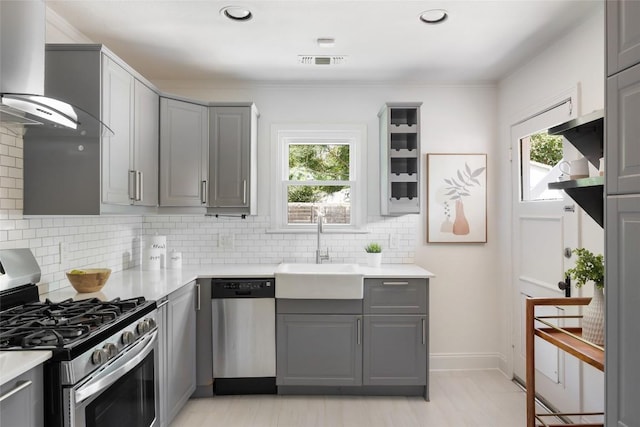 5306 Harmon Ave, Austin, TX 78751 - kitchen with stainless steel appliances, gray cabinets, wall chimney range hood, a sink, and plenty of natural light