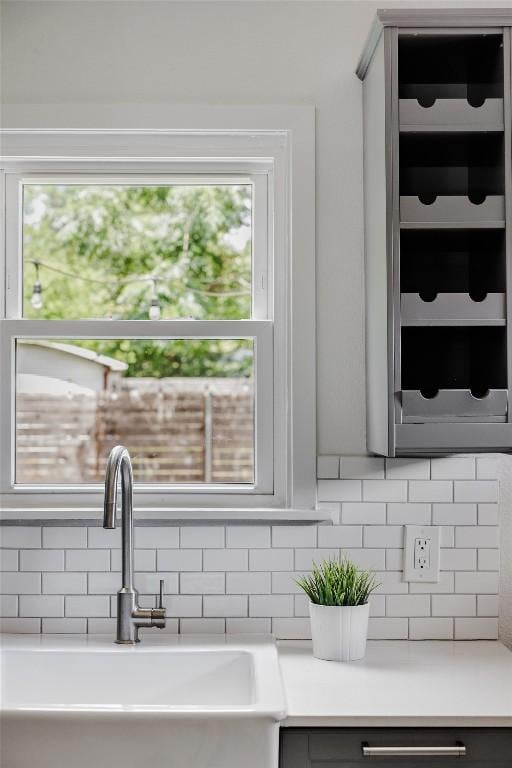 5306 Harmon Ave, Austin, TX 78751 - kitchen featuring a sink, decorative backsplash, light countertops, and gray cabinetry
