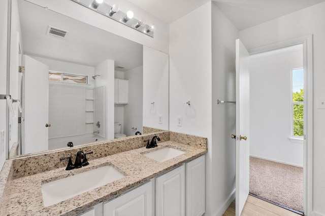 18109 Canopy Ln, Manor, TX 78653 - full bath featuring double vanity, toilet, shower / washtub combination, and wood finished floors