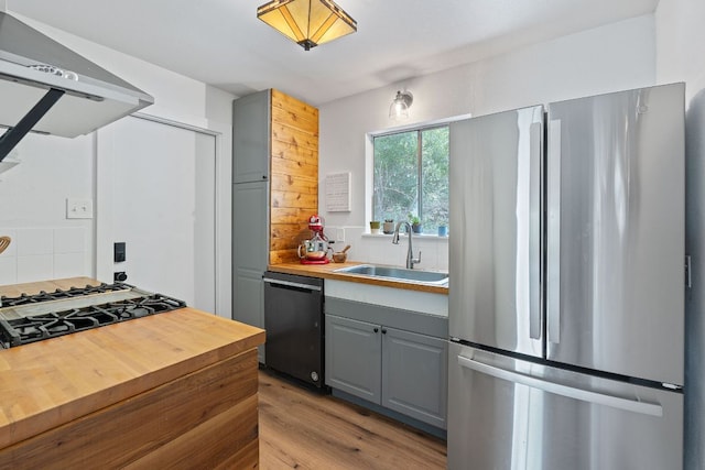 5206 Ledesma Rd, Austin, TX 78721 - kitchen with freestanding refrigerator, dishwashing machine, gray cabinets, a sink, and exhaust hood