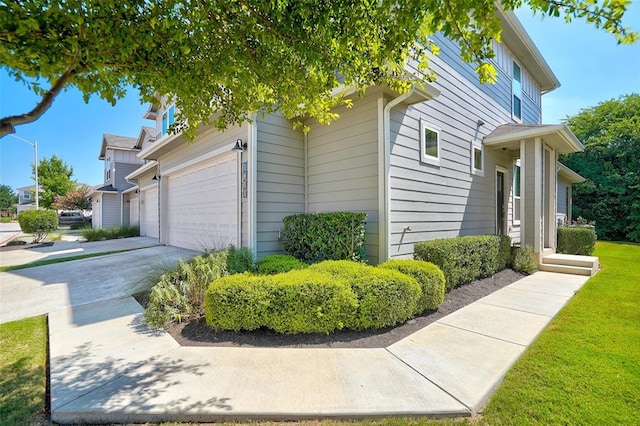 1801 Roseburg Dr Unit 29, Austin, TX 78754 - view of side of home featuring driveway, a garage, and a lawn