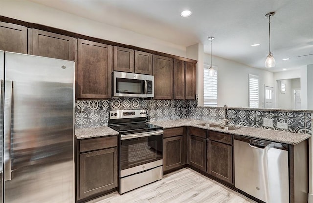 1801 Roseburg Dr Unit 29, Austin, TX 78754 - kitchen with stainless steel appliances, a sink, dark brown cabinets, tasteful backsplash, and recessed lighting