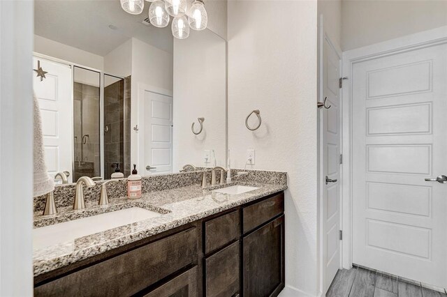 1801 Roseburg Dr Unit 29, Austin, TX 78754 - bathroom featuring a shower stall, double vanity, wood finished floors, and a chandelier