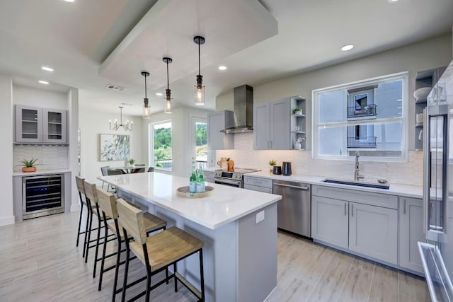 4300 Mansfield Dam Rd Unit 1231, Austin, TX 78734 - kitchen with stainless steel appliances, beverage cooler, wall chimney exhaust hood, a sink, and gray cabinets