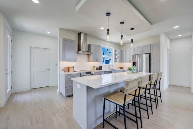 4300 Mansfield Dam Rd Unit 1231, Austin, TX 78734 - kitchen featuring wall chimney exhaust hood, stainless steel appliances, gray cabinets, light wood-style flooring, and light countertops