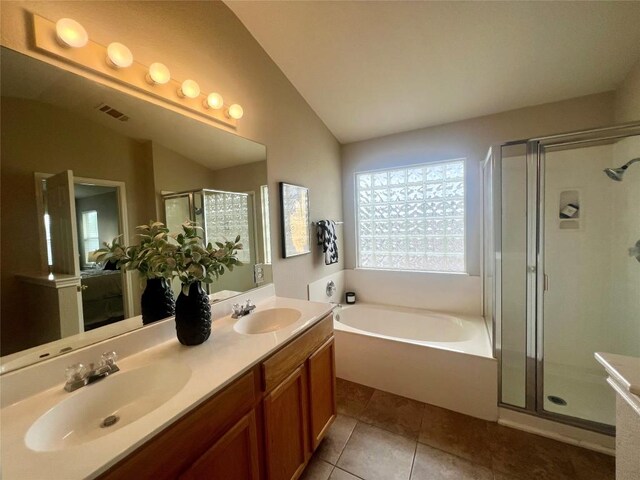 144 Sampson, Kyle, TX 78640 - bathroom with lofted ceiling, a garden tub, a shower stall, double vanity, and tile patterned flooring