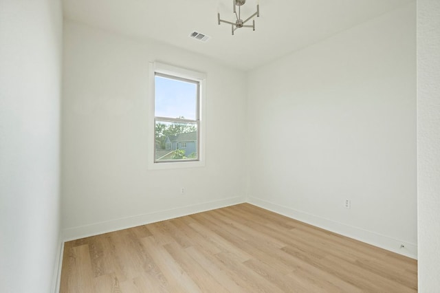 4048 Berkman Dr, Austin, TX 78723 - spare room with light wood finished floors, a chandelier, and baseboards