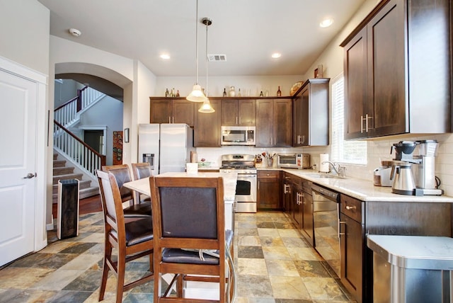 3808 Mattie St, Austin, TX 78723 - kitchen with stainless steel appliances, light countertops, a sink, a center island, and light stone finish floors