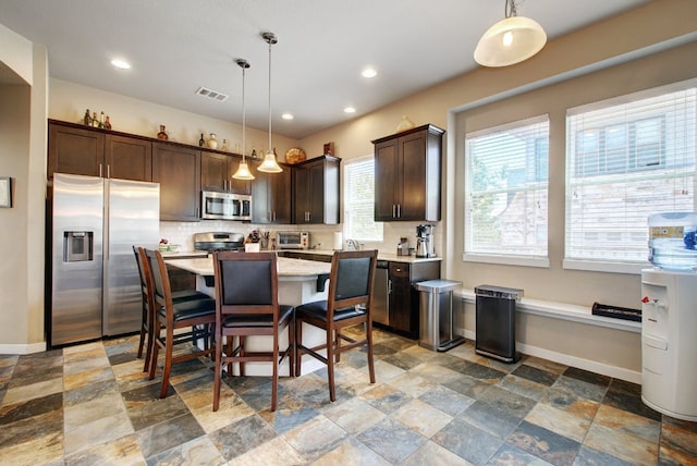 3808 Mattie St, Austin, TX 78723 - kitchen with appliances with stainless steel finishes, dark brown cabinets, stone finish flooring, tasteful backsplash, and baseboards