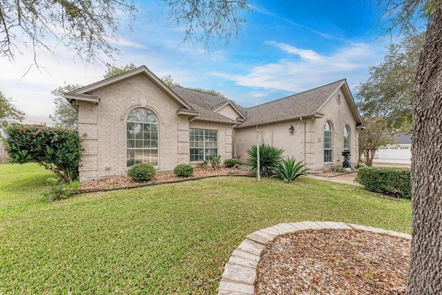 1610 Meadow Ln, Lockhart, TX 78644 - view of front facade with a front lawn, brick siding, and roof with shingles