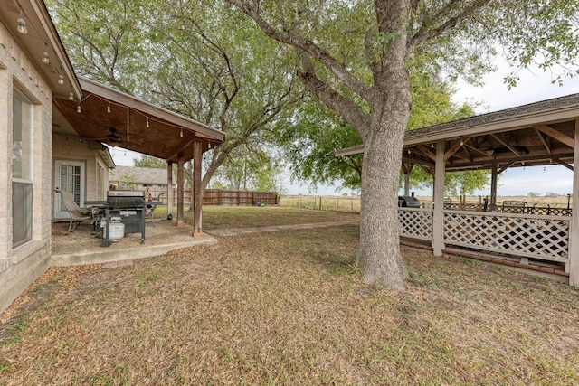 1610 Meadow Ln, Lockhart, TX 78644 - fenced backyard featuring a gazebo, a ceiling fan, and a patio area