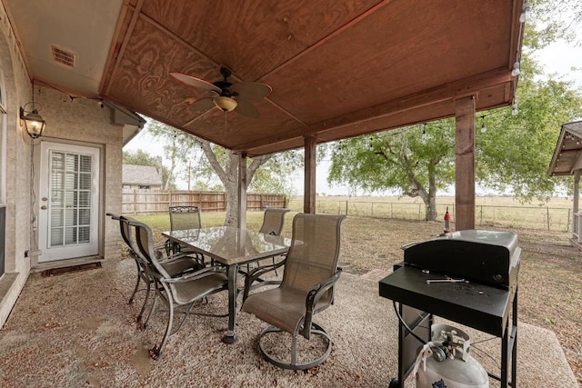 1610 Meadow Ln, Lockhart, TX 78644 - fenced backyard featuring outdoor dining area, area for grilling, a ceiling fan, and a patio area