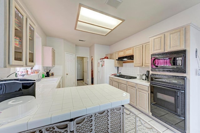1610 Meadow Ln, Lockhart, TX 78644 - kitchen featuring black appliances, under cabinet range hood, tile countertops, and light brown cabinets