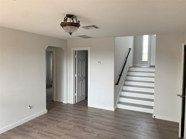 4102 Glendale Ln, Lago Vista, TX 78645 - unfurnished living room with arched walkways, wood finished floors, and stairs