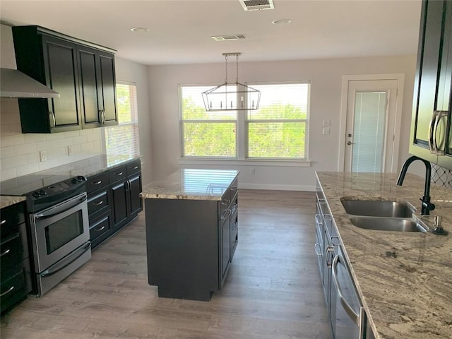 4102 Glendale Ln, Lago Vista, TX 78645 - kitchen with stainless steel appliances, wall chimney range hood, light wood-style floors, tasteful backsplash, and recessed lighting